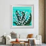 Tablou canvas cu clopotei albi intr-un living, deasupra unei canapele crem
