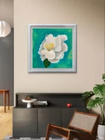 Tablou canvas cu floare alba pe un perete bej, deasupra unei comode negre