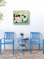 Tablou canvas Primavara Inflorita pe un perete alb, deasupra unei mese cu doua scaune albastre