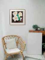 Tablou canvas pictat in acrilic, pe un perete alb, langa un fotoliu din ratan