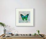 Tablou Green butterfly cu paspartu, pe un perete gri, deasupra unei mese cu set de ceai