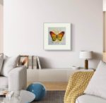 Tablou cu fluture pictat manual, pe peretele unui living luminos cu canapea alba